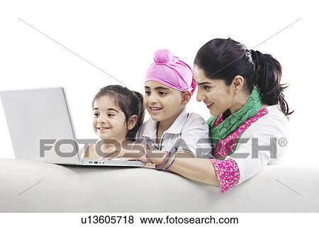 Mother and kids looking at a laptop View Large Photo Image Stock Photo - Mother and kids looking at a laptop. Fotosearch