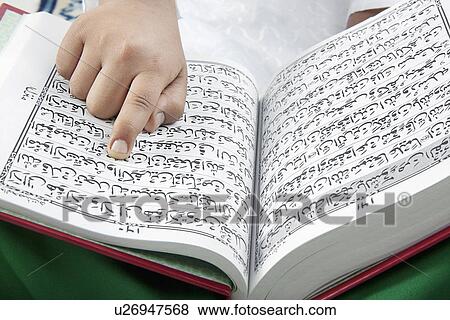 Muslim boy reading the Quran View Large Photo Image Stock Photo - Muslim boy reading the Quran. Fotosearch