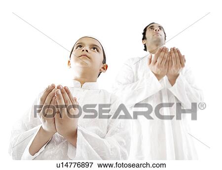 Stock Photo - Muslim man and his son praying. Fotosearch