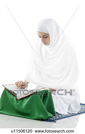 Stock Image - Muslim woman reading the Quran. Fotosearch