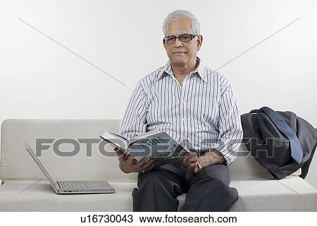 Stock Image - Old man reading a book. Fotosearch