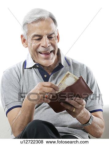 Stock Photo - Old man taking out money from his wallet. Fotosearch