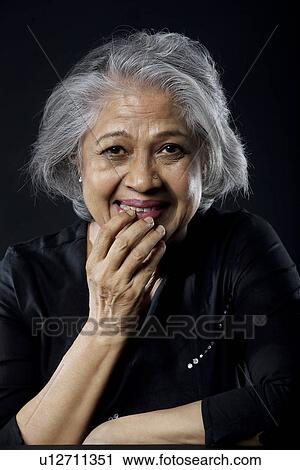 Stock Image - Old woman chuckling. Fotosearch