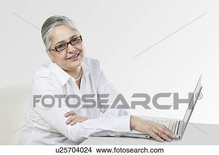 Picture - Old woman with a laptop. Fotosearch