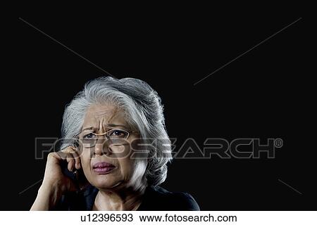 Stock Image - Old woman with a sad face. Fotosearch
