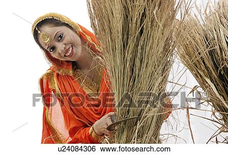 Stock Photograph - Sikh woman with a sickle and bale of hay. Fotosearch