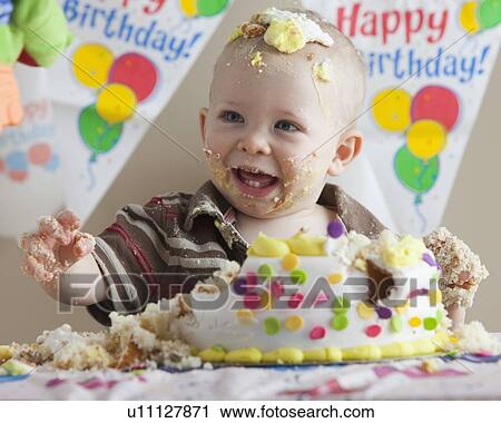 Stock Image - Baby covered in birthday cake. Fotosearch