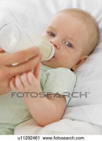 Stock Image - Baby drinking from bottle. Fotosearch