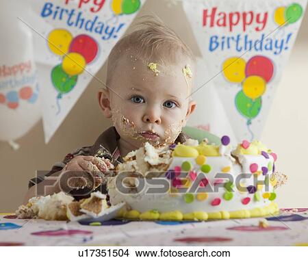 Picture - Baby eating birthday cake. Fotosearch