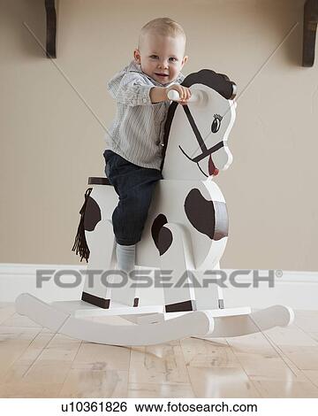 Baby on rocking horse View Large Photo Image Stock Photograph - Baby on rocking horse. Fotosearch