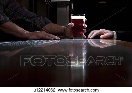 Bartender serving a beer View Large Photo Image Stock Image - Bartender serving a beer. Fotosearch