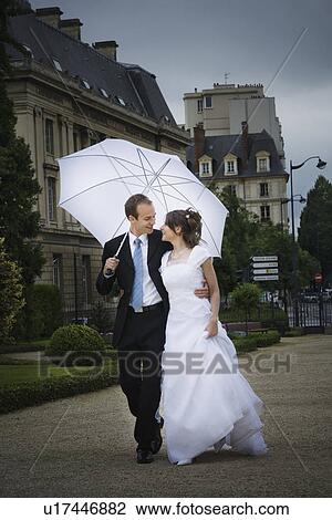 Bride and groom walking in the rain View Large Photo Image Stock Image - Bride and groom walking in the rain. Fotosearch