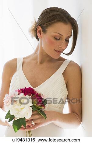 Bride holding bouquet of flowers View Large Photo Image Stock Photograph - Bride holding bouquet of flowers. Fotosearch