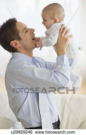 Businessman holding baby View Large Photo Image Stock Photograph - Businessman holding baby. Fotosearch