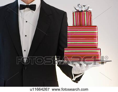 Stock Photo - Butler holding gifts. Fotosearch