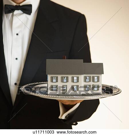 Butler holding toy house on tray View Large Photo Image Stock Image - Butler holding toy house on tray. Fotosearch