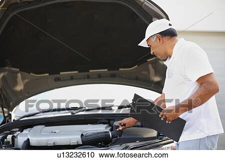 Stock Image - Checking car engine. Fotosearch