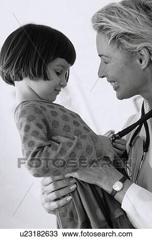 Stock Image - Child having check-up at doctor's office. Fotosearch