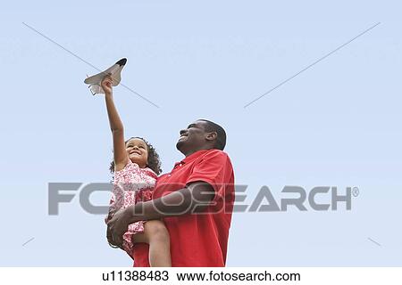 Stock Image - Child playing with toy plane. Fotosearch
