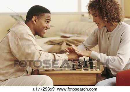 Stock Photo - Couple playing chess. Fotosearch