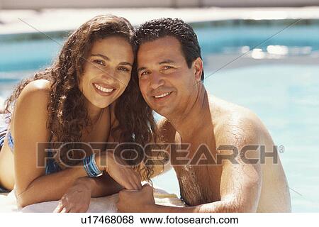 Stock Photo - Couple relaxing by the pool. Fotosearch