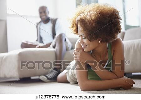 Couple relaxing in living room View Large Photo Image Stock Photography - Couple relaxing in living room. Fotosearch