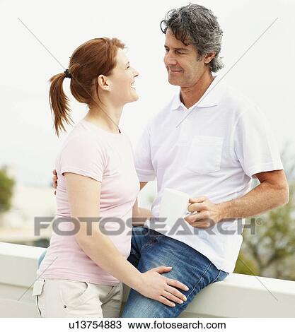 Stock Image - Couple relaxing on balcony. Fotosearch