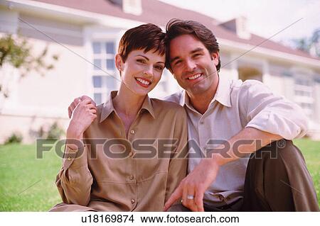 Picture - Couple sitting on lawn. Fotosearch