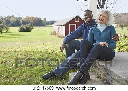 Stock Photo - Couple sitting on porch. Fotosearch