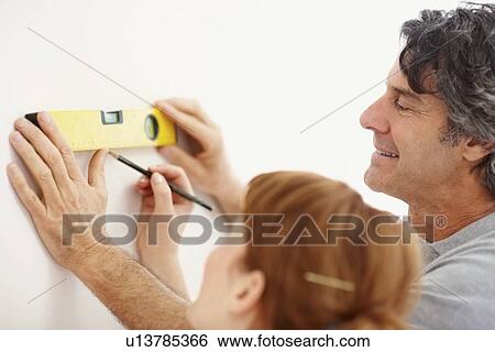 Stock Photograph - Couple using a level. Fotosearch