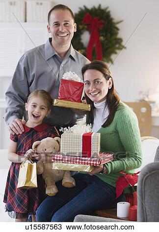 Stock Image - Family holding presents. Fotosearch