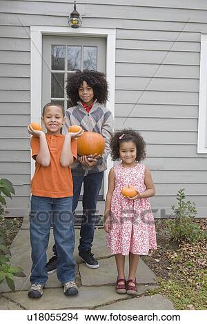 Family holding pumpkins View Large Photo Image Picture - Family holding pumpkins. Fotosearch