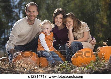 Stock Photo - Family in pumpkin patch. Fotosearch