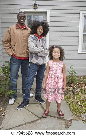 Stock Photo - Family standing in front of house. Fotosearch