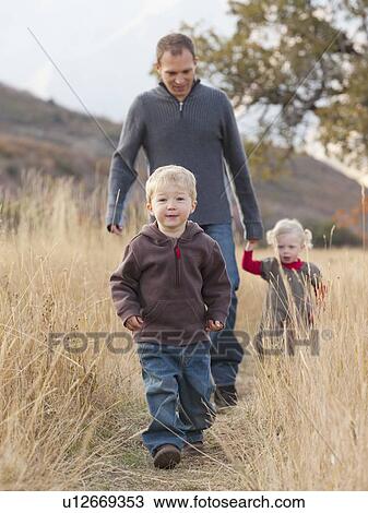 Family walking in a meadow View Large Photo Image Stock Image - Family walking in a meadow. Fotosearch