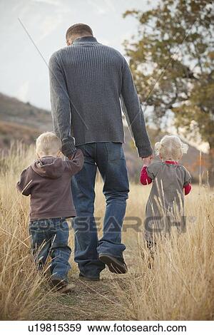 Family walking in a meadow View Large Photo Image Stock Photo - Family walking in a meadow. Fotosearch