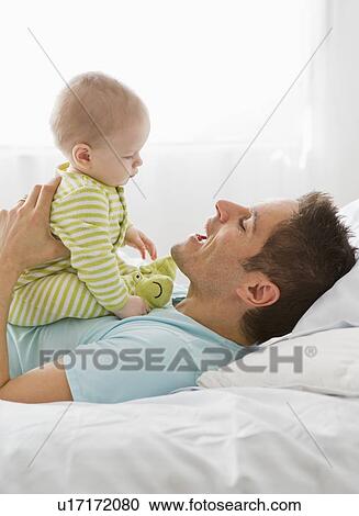 Stock Image - Father and baby playing. Fotosearch