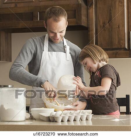 Stock Image - Father and daughter baking. Fotosearch