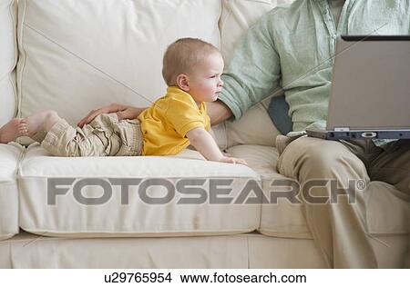 Father and son on couch View Large Photo Image Picture - Father and son on couch. Fotosearch