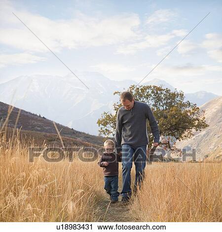 Stock Image - Father and son walking outdoors. Fotosearch