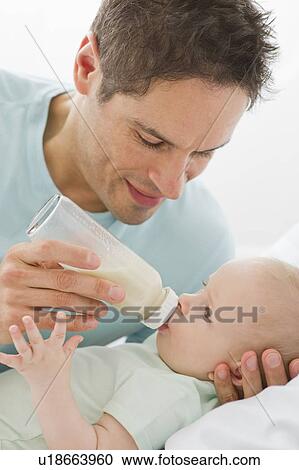 Stock Image - Father feeding baby. Fotosearch