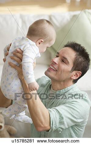 Stock Image - Father holding baby. Fotosearch