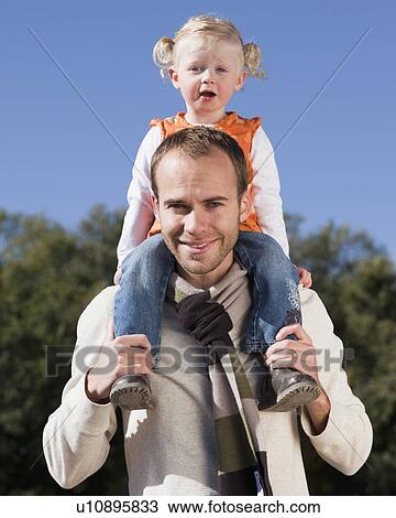 Father holding daughter on his shoulders View Large Photo Image Stock Image - Father holding daughter on his shoulders. Fotosearch