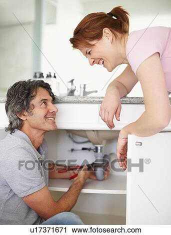 Stock Image - Fixing a leaky sink. Fotosearch