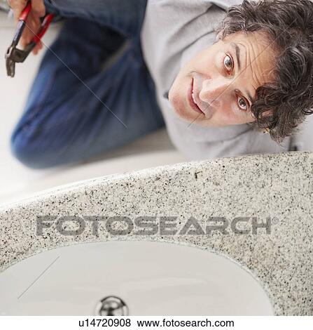 Stock Photo - Fixing a leaky sink. Fotosearch