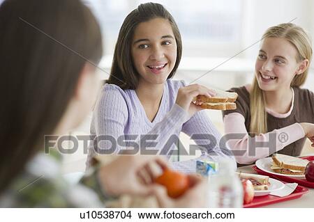 Picture - Friends eating in cafeteria. Fotosearch