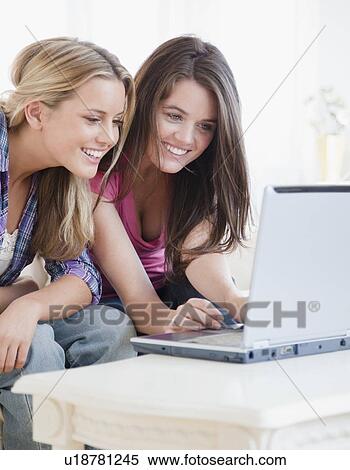 Friends looking at laptop View Large Photo Image Stock Photography - Friends looking at laptop. Fotosearch