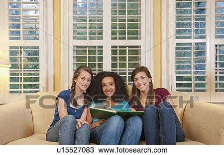 Stock Image - Friends reading book. Fotosearch