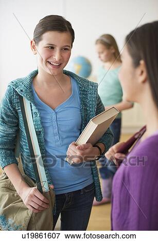 Stock Photo - Friends socializing in classroom. Fotosearch