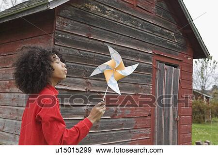 Girl blowing toy windmill View Large Photo Image Stock Photo - Girl blowing toy windmill. Fotosearch